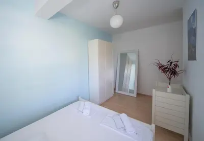 a bedroom with a white bed with white shoes on it at Sunshine in Kotor