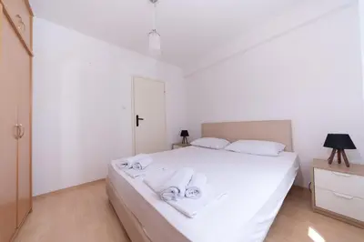 a bedroom with a white bed with towels on it at Sunshine in Kotor