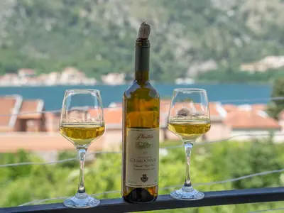 a bottle of wine and two glasses on a table at Sunshine in Kotor