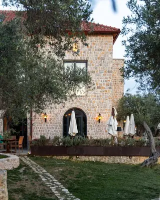 a brick building with umbrellas in front of it at MASHTRA - The Olive House in Ulcinj