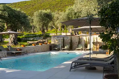 a swimming pool with chairs and umbrellas at MASHTRA - The Olive House in Ulcinj