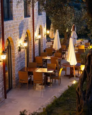 a restaurant with tables and umbrellas on a patio at MASHTRA - The Olive House in Ulcinj