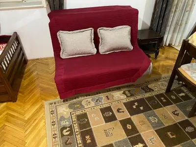 a red couch with two pillows in a living room at VivaV in Budva
