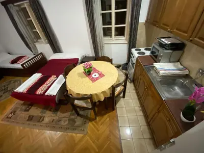 a small kitchen with a table with flowers on it at VivaV in Budva
