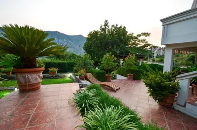 a patio with benches and plants in a yard at Djardin in Kotor