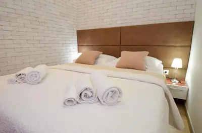 a bedroom with a large white bed with towels on it at Djardin in Kotor