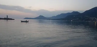 a man in a boat on a large body of water at Apartman na najboljoj lokaciji , nedaleko od plaže in Bar