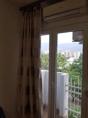 a sliding glass door with a view of a balcony at Apartman na najboljoj lokaciji , nedaleko od plaže in Bar