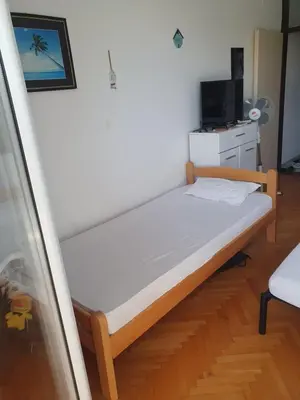 a small bedroom with a bed and a tv at Apartman na najboljoj lokaciji , nedaleko od plaže in Bar