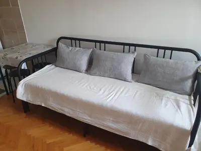 a bed with four pillows on it in a room at Apartman na najboljoj lokaciji , nedaleko od plaže in Bar