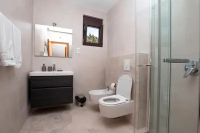 a bathroom with a toilet and a sink and a shower at Zia Apartments in Bar