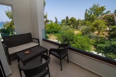 a balcony with a table and chairs and a large window at Zia Apartments in Bar