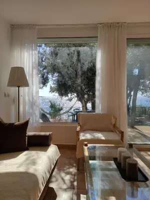 a living room with a couch and a large window at Family Seaside Holm Oak Villa with Private Rocky Beach in Bar