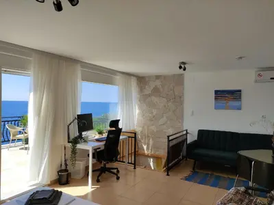 a living room with a couch and a desk with a computer at Family Seaside Holm Oak Villa with Private Rocky Beach in Bar