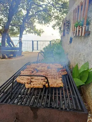 a bunch of food cooking on a grill at Family Seaside Holm Oak Villa with Private Rocky Beach in Bar