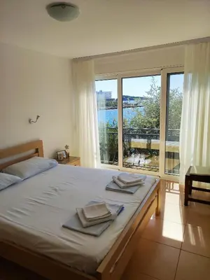 a bedroom with a bed and a large window at Family Seaside Holm Oak Villa with Private Rocky Beach in Bar
