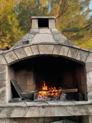 a stone oven with a fire in it at Apartman Ana Zeleni pojas in Bar