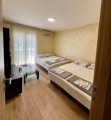 two beds in a room with a window at Apartman Sofija Budva in Budva