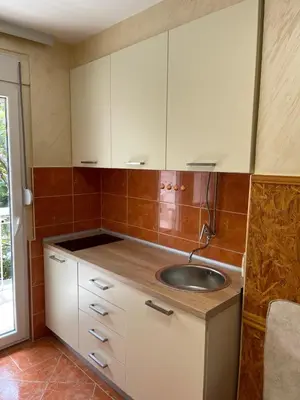 a kitchen with a sink and white cabinets at Apartman Sofija Budva in Budva