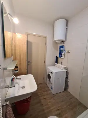 a bathroom with a sink and a washing machine at Apartman Natalia in Podgorica