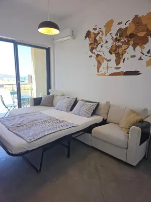 a living room with a couch and a world map on the wall at Modern Top Floor Sea View 3BR with Pools, Spa & Fitness in Becici