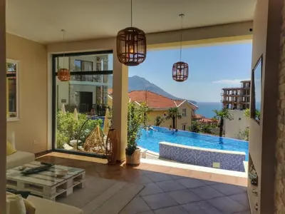 a living room with a view of a swimming pool at Modern Top Floor Sea View 3BR with Pools, Spa & Fitness in Becici
