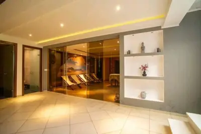 a living room with glass walls and a table at Modern Top Floor Sea View 3BR with Pools, Spa & Fitness in Becici