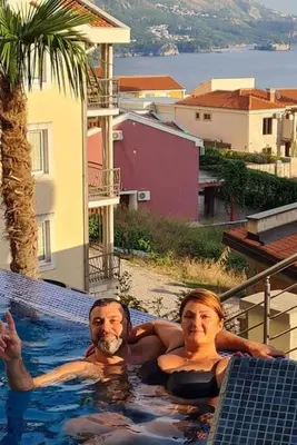 a man and a woman in a swimming pool at Modern Top Floor Sea View 3BR with Pools, Spa & Fitness in Becici
