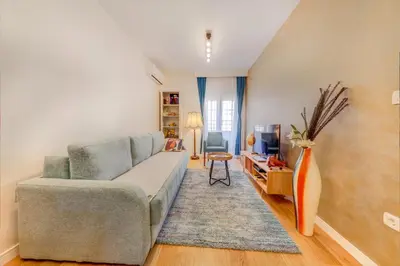 a living room with a couch and a tv at Consulate in Podgorica