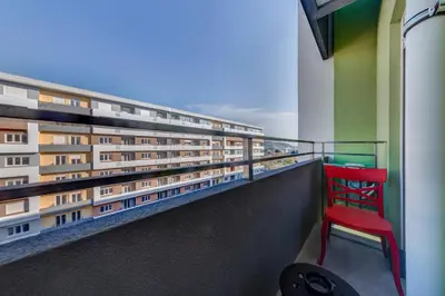 a red chair sitting on the balcony of a building at Consulate in Podgorica