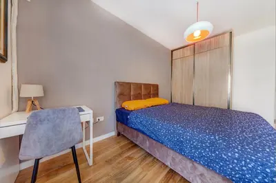 a bedroom with a bed and a desk and a chair at Consulate in Podgorica