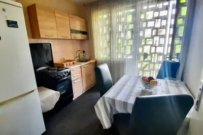 a small kitchen with a table and a refrigerator at Cute, spacious apt in the heart of the old town in Podgorica
