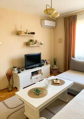 a living room with a tv and a table at Cute, spacious apt in the heart of the old town in Podgorica