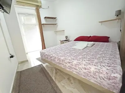 a bedroom with a large bed with red pillows at Java apartments - S & J in Dobrota