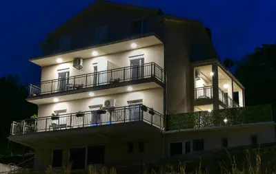 a large white building with balconies at night at Java apartments - S & J in Dobrota