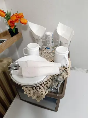 a tray with plates and cups on a table with flowers at Java apartments - S & J in Dobrota