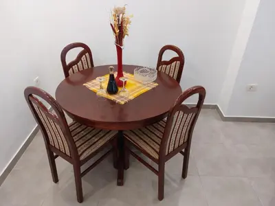 a wooden table with chairs and a vase with flowers on it at Apartment Angel in Kotor