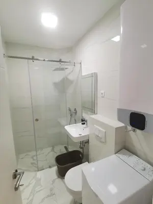 a white bathroom with a toilet and a sink at Apartments LORA Zmajeva, 7 in Budva