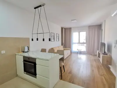a kitchen and living room with a table and a couch at Apartments LORA Zmajeva, 7 in Budva