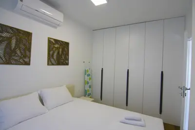 a white bedroom with a bed and a closet at Apartments LORA Zmajeva, 7 in Budva