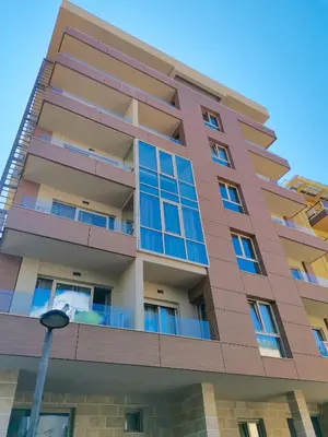 a tall building with blue windows and a street light at Apartments LORA Zmajeva, 7 in Budva
