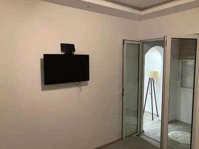 a flat screen tv on a wall in a room at Stan na dan Bogdan in Podgorica