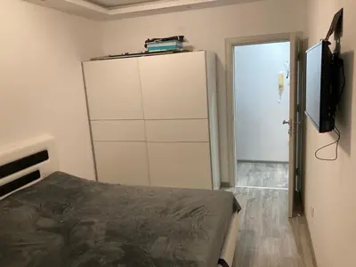 a bedroom with a bed and a dresser and a television at Stan na dan Bogdan in Podgorica