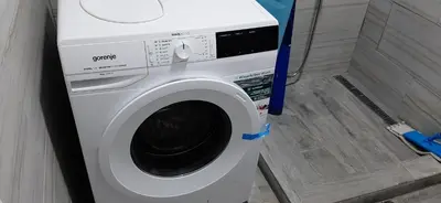 a washing machine sitting in a bathroom next to a shower at SKADAr LAKE SARA 3 DM in Cetinje