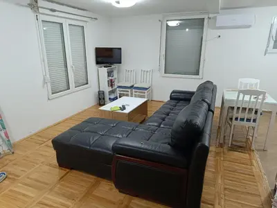 a living room with a black leather couch and a table at SKADAr LAKE SARA 3 DM in Cetinje