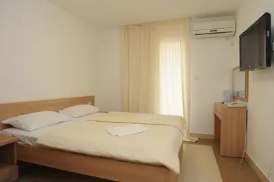 a bedroom with a bed with a flat screen tv at Hotel Anita in Budva