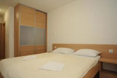 a bedroom with a large bed with white sheets at Hotel Anita in Budva