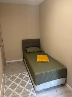 a small bedroom with a bed with a yellow blanket on it at Max Apartments in Podgorica