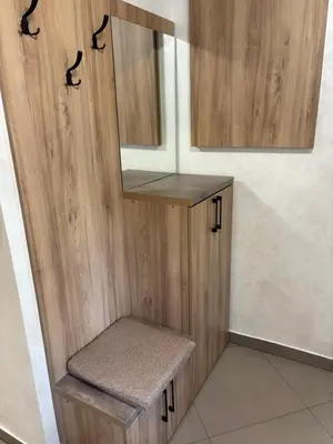 a bathroom with a wooden cabinet and a mirror at Max Apartments in Podgorica