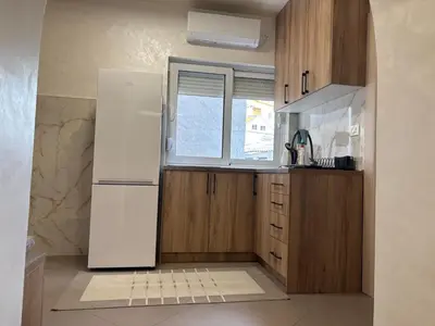 a kitchen with a white refrigerator and a window at Max Apartments in Podgorica